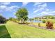 A well-maintained backyard with lush green grass, shrubs, and a lake view at 3349 Sagebrush St, Harmony, FL 34773