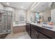Bright bathroom featuring double vanity sinks, a soaking tub, and a walk-in shower at 3349 Sagebrush St, Harmony, FL 34773