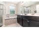 Modern bathroom featuring a double vanity, glass-enclosed shower, and a relaxing soaking tub at 3349 Sagebrush St, Harmony, FL 34773
