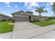 View of the charming single-story house featuring a well-kept lawn and a paved driveway at 3349 Sagebrush St, Harmony, FL 34773