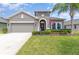 Charming single-story home featuring a well-maintained lawn, arched entryway, and an attached two-car garage at 3349 Sagebrush St, Harmony, FL 34773