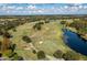 An aerial view shows a lush golf course with strategically placed bunkers, water hazards, and mature trees at 3349 Sagebrush St, Harmony, FL 34773
