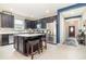 Well-lit kitchen featuring dark cabinetry, a stainless steel refrigerator, and a central island with barstool seating at 3349 Sagebrush St, Harmony, FL 34773