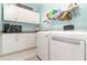 Functional laundry room with white cabinets, granite countertop, modern washer and dryer, and ample storage space at 3349 Sagebrush St, Harmony, FL 34773