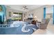 Bright living room featuring a stylish blue rug, comfortable seating, and sliding glass doors to the lanai at 3349 Sagebrush St, Harmony, FL 34773