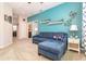 Inviting living room with a plush blue sofa, light-colored carpet, and decor shelving on the bright blue accent wall at 3349 Sagebrush St, Harmony, FL 34773