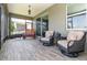Relaxing covered patio with wood-look tile, sliding glass doors, and stylish seating, perfect for enjoying the outdoors at 3349 Sagebrush St, Harmony, FL 34773