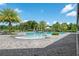 A beautiful swimming pool is surrounded by palm trees and elegant stone pavers on a bright sunny day at 3349 Sagebrush St, Harmony, FL 34773