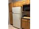 Functional kitchen area featuring a refrigerator, microwave, and ample wooden cabinet storage space at 3417 Westchester Square Blvd # 202, Orlando, FL 32835
