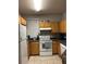 Efficient kitchen equipped with wood cabinets, essential appliances, and a functional layout at 3417 Westchester Square Blvd # 202, Orlando, FL 32835