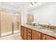 Bright and elegant bathroom with a double vanity, granite countertops, and a glass-enclosed shower at 408 Southfield St, Kissimmee, FL 34747