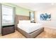 Serene bedroom with a king bed, calming green walls, and ample natural light from the windows at 408 Southfield St, Kissimmee, FL 34747