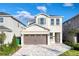 Two-story home features a paved driveway, two-car garage, and neutral exterior paint scheme at 408 Southfield St, Kissimmee, FL 34747