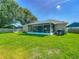 Spacious backyard featuring a screened patio, lush green lawn, and well-maintained landscaping at 439 Lake Daisy Dr, Winter Haven, FL 33884