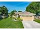 Charming single-story home featuring a well-manicured lawn, inviting front entrance, and attached two car garage at 439 Lake Daisy Dr, Winter Haven, FL 33884