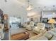 Bright living room featuring vaulted ceiling, ceiling fan, and multiple white leather recliner chairs at 439 Lake Daisy Dr, Winter Haven, FL 33884