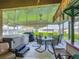 Relaxing screened patio area with a hot tub, dining set, and a tiki bar for enjoying the outdoors at 439 Lake Daisy Dr, Winter Haven, FL 33884