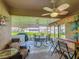 Enclosed patio featuring a Tiki bar, ceiling fan, and outdoor seating at 439 Lake Daisy Dr, Winter Haven, FL 33884