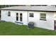 The backyard features a well-maintained lawn, central air conditioning, and access through white-framed glass doors at 49 Orange Park Blvd, Lake Wales, FL 33898