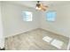 Bright bedroom featuring neutral walls, tile floors, ceiling fan, and natural light from two windows at 49 Orange Park Blvd, Lake Wales, FL 33898