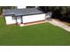 A white home showing a green lawn, gray roof, and a driveway at 49 Orange Park Blvd, Lake Wales, FL 33898