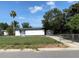 Exterior of the home with a chain-link fence, driveway, and a well-maintained lawn at 49 Orange Park Blvd, Lake Wales, FL 33898