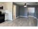 Open-concept living area with kitchen access, ceiling fan, and gray walls at 49 Orange Park Blvd, Lake Wales, FL 33898