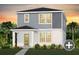 Charming two-story home featuring gray siding, a welcoming front porch, and lush landscaping at 5039 Starling Bird Ln, St Cloud, FL 34771