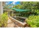 Backyard koi pond with surrounding brick pathway and lush greenery, shaded by a green sun sail at 614 Lake Ave, Orlando, FL 32801