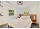 Minimalist bedroom features a wood headboard, white bedding, and ample natural light at 614 Lake Ave, Orlando, FL 32801