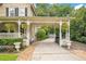 Classic home with porte cochere, hanging ferns, and meticulously maintained landscaping creates a welcoming entrance at 614 Lake Ave, Orlando, FL 32801