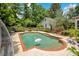 Inviting backyard pool with brick trim, surrounded by a lush yard, fencing, and a detached garage at 614 Lake Ave, Orlando, FL 32801