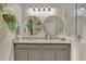 Stylish bathroom featuring double round mirrors, granite counters and a glass-enclosed shower with a tile accent at 6527 Silver Queen Way, Windermere, FL 34786