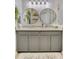 Bright bathroom vanity with double round mirrors, granite countertops and stylish gray cabinetry at 6527 Silver Queen Way, Windermere, FL 34786