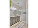 Modern bathroom featuring a glass-enclosed shower and a granite-topped vanity with double, round mirrors at 6527 Silver Queen Way, Windermere, FL 34786