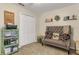 Inviting bedroom features a tufted sofa, shelves, and a closet, providing space and tranquility at 6527 Silver Queen Way, Windermere, FL 34786