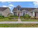 Charming townhome featuring lush landscaping, a welcoming front door, and an eye-catching dormer window at 6527 Silver Queen Way, Windermere, FL 34786