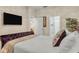 Serene main bedroom with a cozy bed, a mounted TV, and ensuite bathroom doors for convenience at 6527 Silver Queen Way, Windermere, FL 34786