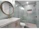 Beautiful bathroom with a round mirror, blue tiling, and glass shower at 719 Stevelynn Cir, Winter Garden, FL 34787