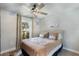Cozy bedroom featuring a bed with decorative pillows, a ceiling fan, and a window overlooking the backyard at 719 Stevelynn Cir, Winter Garden, FL 34787
