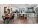 Spacious kitchen features white cabinets, stainless appliances, center island with seating, and dining area with stylish light fixture at 719 Stevelynn Cir, Winter Garden, FL 34787