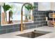Close-up of the kitchen sink featuring a modern faucet, a window, quartz countertops, and subway tile backsplash at 719 Stevelynn Cir, Winter Garden, FL 34787