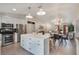 Open floor plan featuring modern kitchen with stainless appliances, center island, connecting to dining and living spaces at 719 Stevelynn Cir, Winter Garden, FL 34787