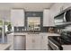 Modern kitchen with stainless steel appliances, white cabinetry, subway tile backsplash, and lots of natural light at 719 Stevelynn Cir, Winter Garden, FL 34787