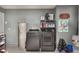 Functional laundry room with modern washer, dryer, storage shelves and gray colored walls at 719 Stevelynn Cir, Winter Garden, FL 34787