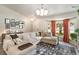 Bright living room featuring a sectional sofa, modern light fixture and natural light from a large window at 719 Stevelynn Cir, Winter Garden, FL 34787