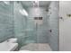 Modern shower featuring light blue tile, rain shower head, and built-in niche at 719 Stevelynn Cir, Winter Garden, FL 34787