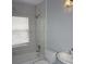 Bathroom featuring a tub-shower combo, white tile, and a window for natural light at 8025 Old Town Dr, Orlando, FL 32819