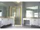 Spacious bathroom has double vanities, a glass shower with gold frame, and large mirrors at 8025 Old Town Dr, Orlando, FL 32819
