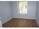 Bright bedroom features wood flooring, light blue walls, and a sunlit window at 8025 Old Town Dr, Orlando, FL 32819